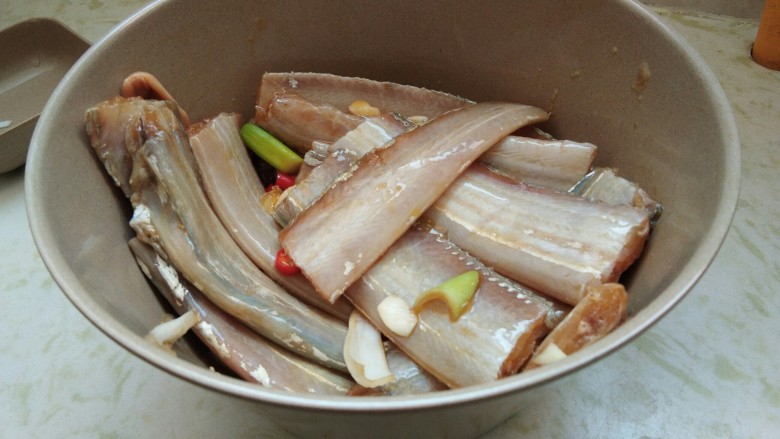 酒香煎带鱼,用筷子拌匀，每段带鱼上都涂上调味料