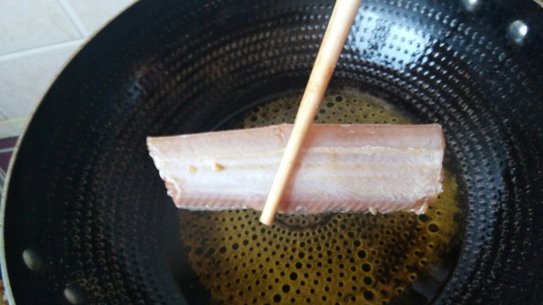 酒香煎带鱼,然后下入腌制好的带鱼。