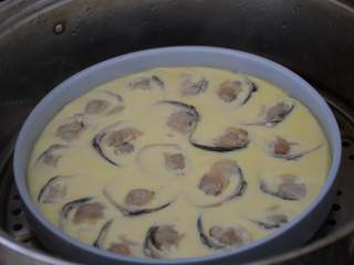 文蛤蒸蛋,盖好锅盖，水烧开后，开始计时，蒸12分钟，关火后焖两分钟再开锅。