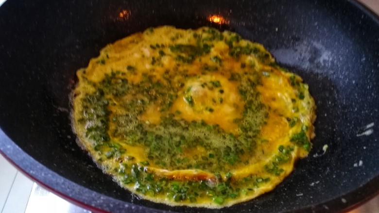 快手早餐之韭苔鸡蛋饼,开始煎鸡蛋饼：要端着锅用锅铲慢慢把蛋液弄平整，不要煎糊了。