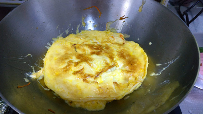 简单易学的寿司,适当时将蛋饼翻面，鸡蛋成饼状后用刀切成条状备用。