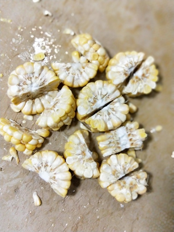 养生玉米海带浓汤,玉米用刀切成小块。