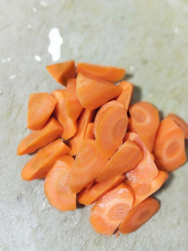 养生玉米海带浓汤,胡萝卜用滚刀法切成小块。