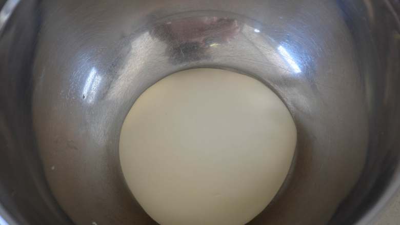 冰花水煎包,发面～面絮倒面板上，揉搓成光滑的面团，放大盆内，盖好，开始发酵。

