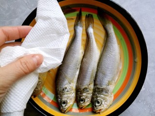 干炸黄花鱼,然后挑去葱姜，用厨房纸将鱼擦去水份。