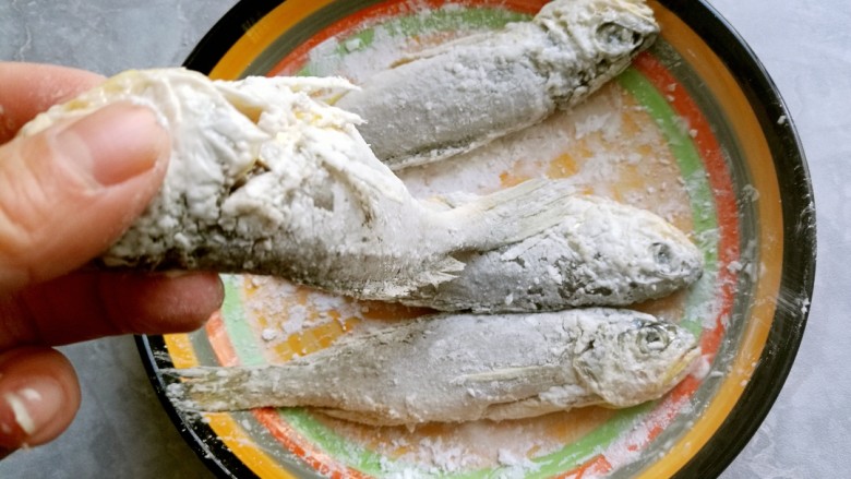 干炸黄花鱼,先抖落一下鱼身上的干淀粉。