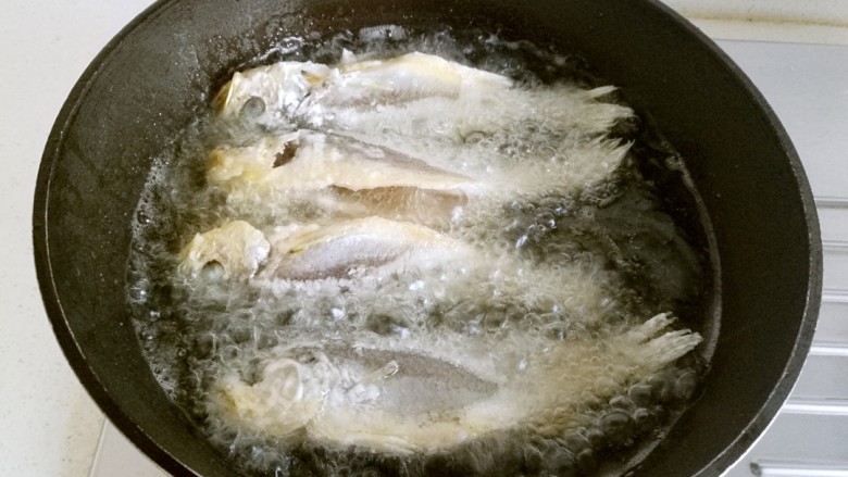 干炸黄花鱼,把鱼放入油锅里炸。