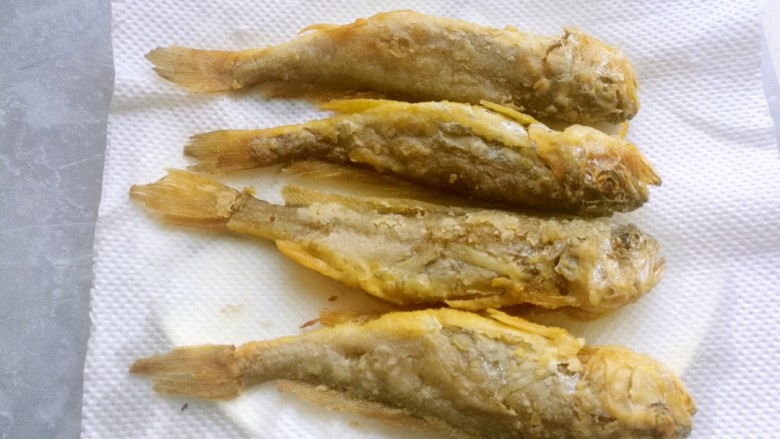干炸黄花鱼,炸至金黄酥脆捞出来，放在厨房纸上控油。