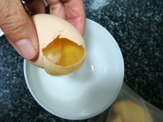入口即化的榴莲饼,轻轻在碗边磕破一个洞，稍微倾斜一下，蛋清就慢慢流出来了。
这个过程一定要慢慢，慢慢地，不然蛋清也跑到碗里就比较麻烦啦。