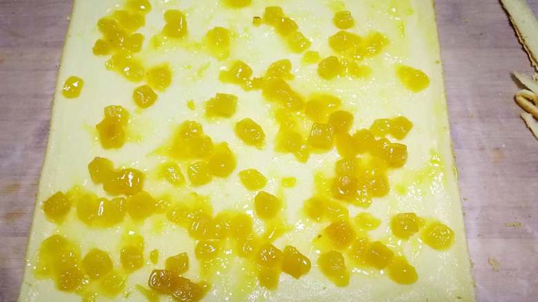 千叶纹蛋糕卷,有花纹一面朝下，尾部切一斜边。铺上果馅。也可以卷奶油。