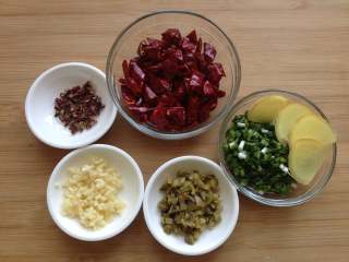 刀口鲫鱼,准备好所需食材：干辣椒剪小段，花椒、小葱切成葱花，蒜末、姜片、榨菜粒
