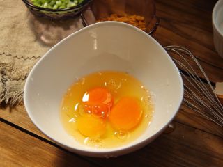 香葱肉松厚蛋烧,鸡蛋打入碗中