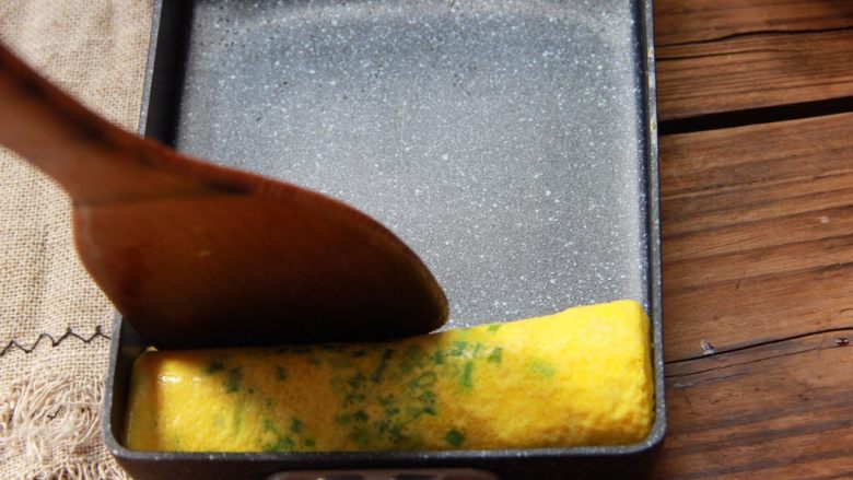 香葱肉松厚蛋烧,煎至凝固时从卷好的蛋卷那侧将蛋皮卷起