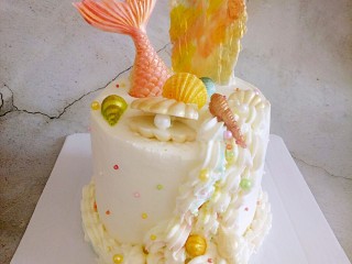美人鱼蛋糕,摆上装饰(贝壳和人鱼尾巴都是白巧克力化好放入硅胶模具里凉了脱模就可以了，特别简单。脱模后抹点色素和食用金粉装饰一下)。
