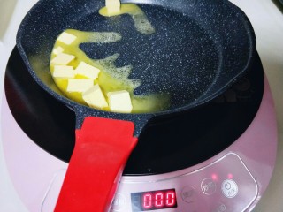 奥利奥雪花酥,选用电磁炉炒菜模式最小档，将切好的黄油放入锅中小火融化。