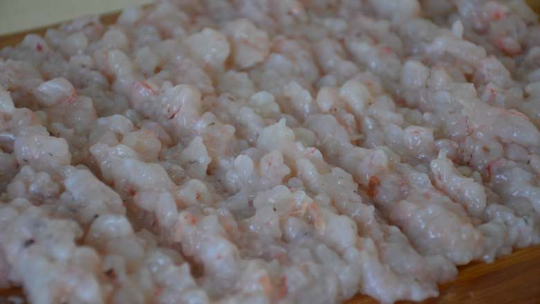 煎虾饼,虾仁放案板上剁碎，尽量剁的细一点，比较容易粘合，好成型。
