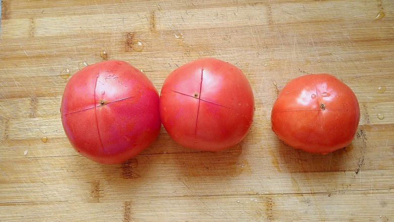 西红柿炖牛肉,在西红柿上面用刀划一个十字。方便西红柿去皮。