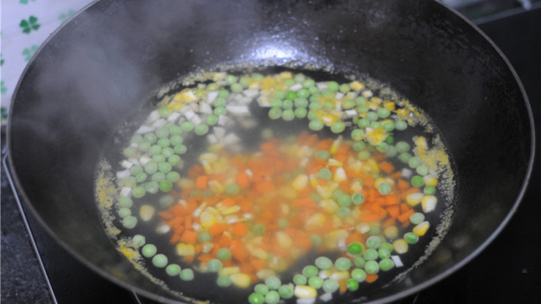 香菇酱黄金蛋炒饭,烧开一锅水，将所有的蔬菜粒倒进去汆烫