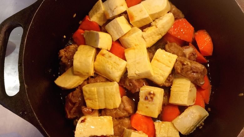 铸铁锅豆腐焖排骨,小心拌炒一下。