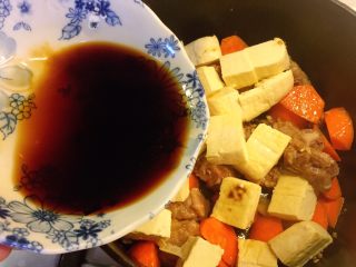 铸铁锅豆腐焖排骨,均匀淋入酱汁。