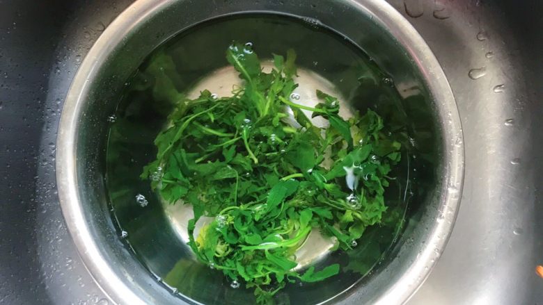 春回大地+荠菜炒年糕,捞出荠菜泡于事先准备好的冷水里，快速降温保持颜色的翠绿