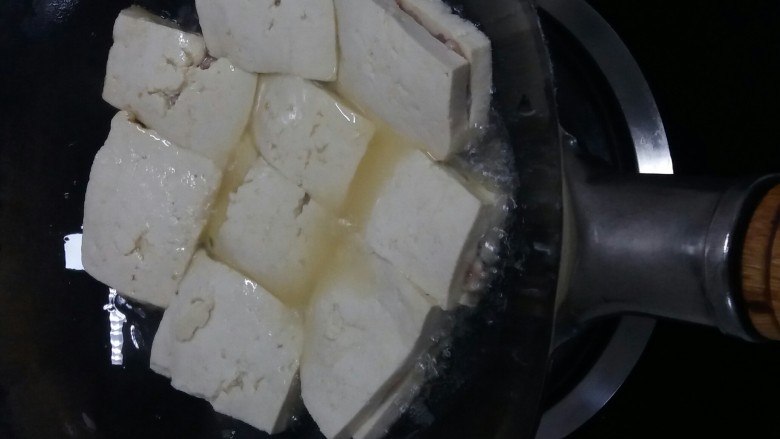秘制油炸豆腐 ,让油洒在豆腐上，方便受热。