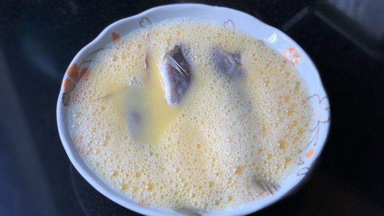 小黄鱼炖蛋,从冰箱里取出小黄鱼，冲一下水，洗去未融化的盐粒，放入蛋液中。