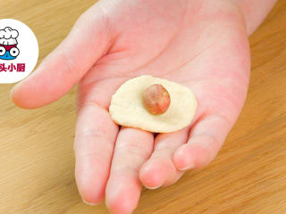 零难度香脆鱼皮花生,取一小块面团搓圆压扁，放入熟花生米1颗