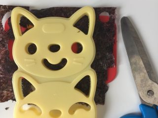 猫咪饭团,开始做猫咪🐱的表情，在硅胶垫上放一片海苔，用套装里的表情压花模具压出表情。