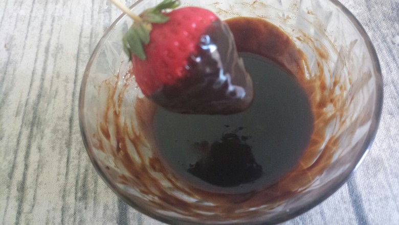 草莓巧克力,如图，四圈都沾上巧克力液，底部可以留一点草莓出来，这样比较好看
