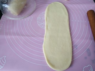 黑米面包,把面团按扁排气，然后分成三块，取一段擀成长牛舌饼状