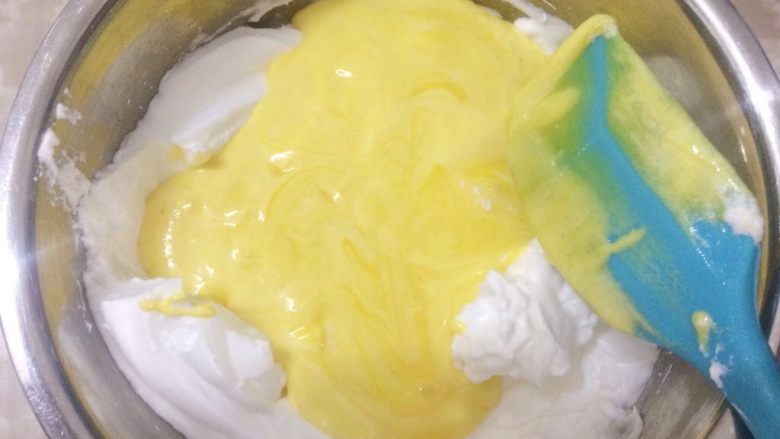 极致柔软的戚风卷,把剩下的蛋黄糊全部倒入蛋白中进行快速的翻拌均匀。（注意：翻拌混合过程一定要快，以免会消泡）