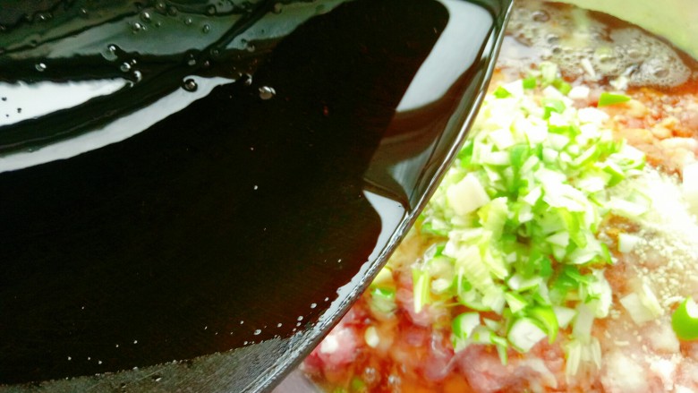 韭菜鲜肉大包子,在馅料盆中放入葱花，然后将刚炸好的油淋在葱花上