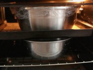 无油无糖燕麦芝麻欧包,盖好保鲜膜，烤箱下层放一碗热水，将发酵盆放入中上层，进行二次发酵，发至两倍大。