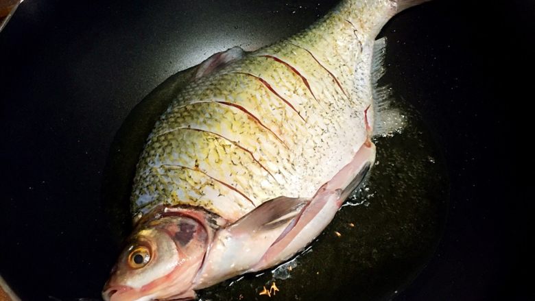 川味干烧臊子鱼,放入鱼中火煎至表面金黄色即可。