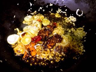 水煮肥牛金针菇,锅中倒入油加热放入葱姜蒜爆香再放入水煮麻辣底料