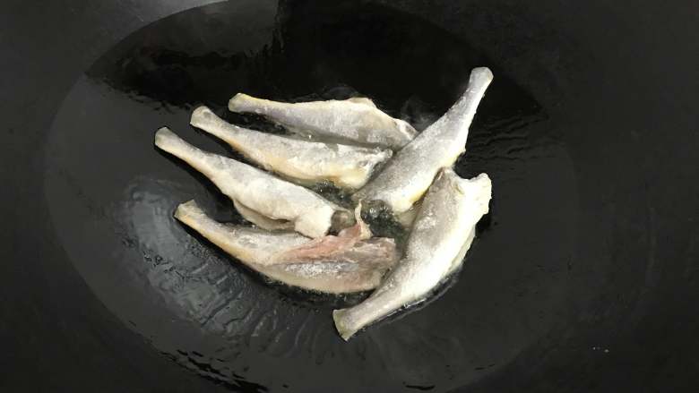 小黄鱼雪菜面,锅中倒入适量油后放入小黄鱼煎制。