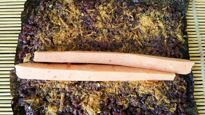 黑米寿司,火腿肠用刀切成条，如图中放在中间