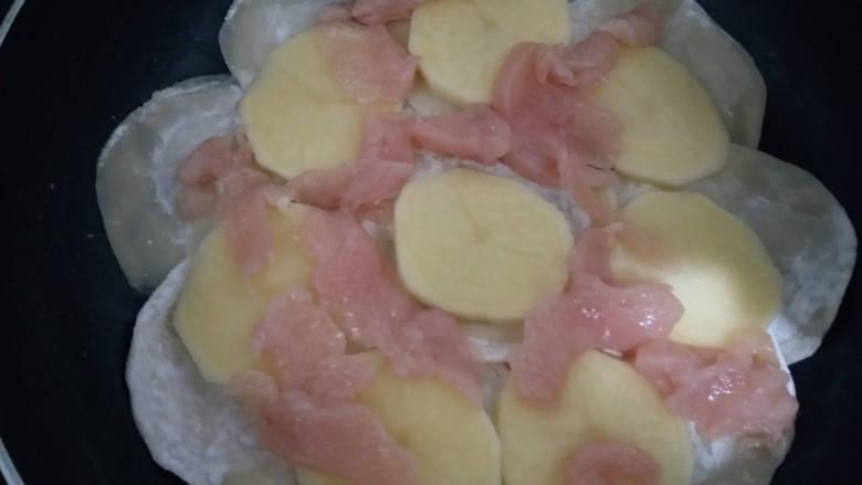 花边披萨~饺子皮平底锅版,放入切好土豆和鸡胸肉平铺在饺子皮上。