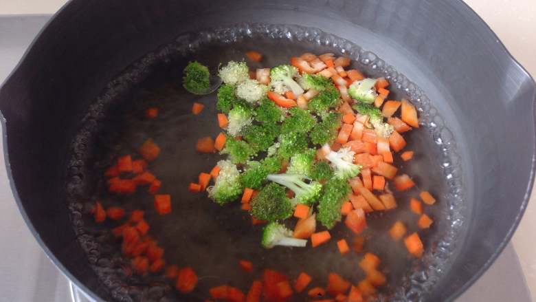 杂蔬培根芝士鸡蛋盏,锅中加水，烧开后滴入几滴油，放入杂蔬丁焯熟