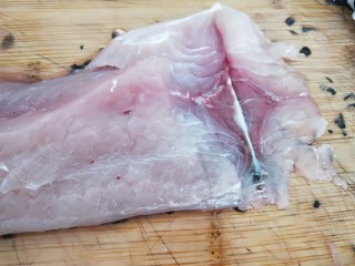 家常酸菜鱼,片鱼肉，如图所示，斜刀片鱼片，第一刀片刀鱼皮为止，不能切断。