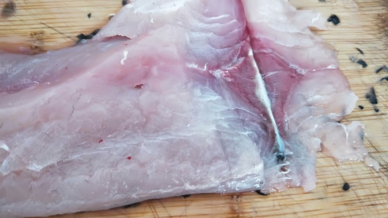家常酸菜鱼,片鱼肉，如图所示，斜刀片鱼片，第一刀片刀鱼皮为止，不能切断。
