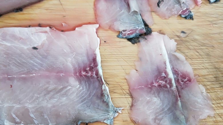 家常酸菜鱼,第二刀片到鱼皮，直接切断。如图所示。
