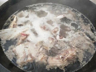 家常酸菜鱼,鱼骨下锅烧开。