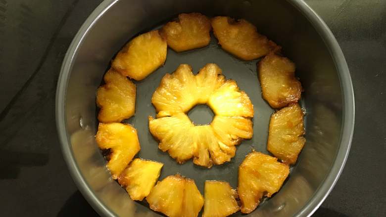 焦糖菠萝反转蛋糕,把菠萝铺入模具底部。