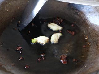 笋干炖肉,锅内放适量的色拉油，放入拍碎的大蒜、花椒八角爆香；