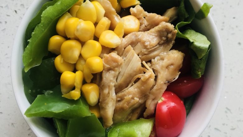 减脂利器：鸡胸沙拉,鸡胸肉用筷子夹成块，并与其他蔬菜放入碗中
