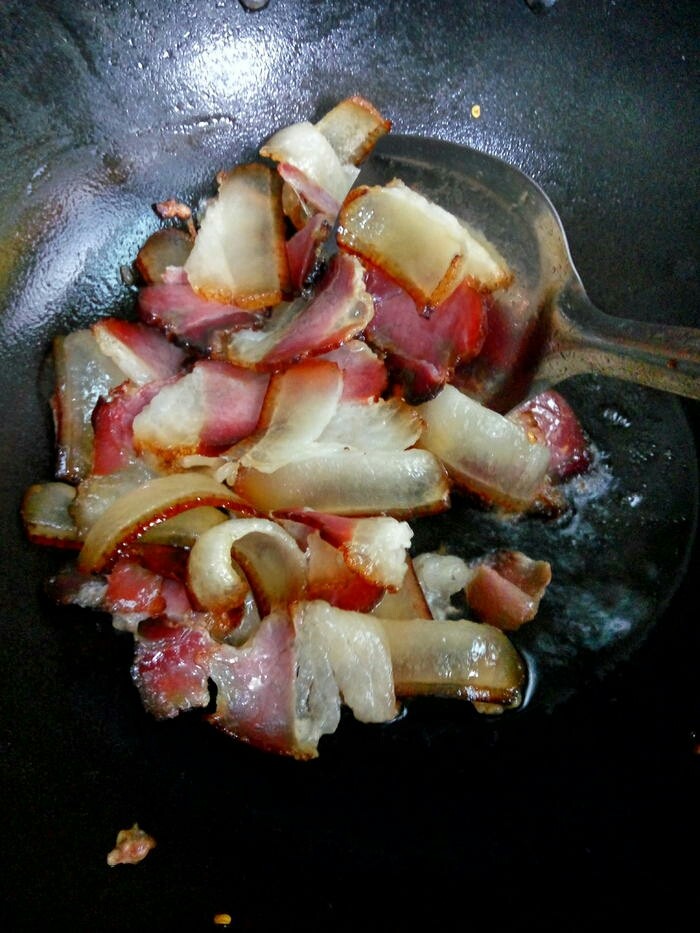 蕨菜炒腊肉,先将腊肉下锅炒出香味，煸出油来。