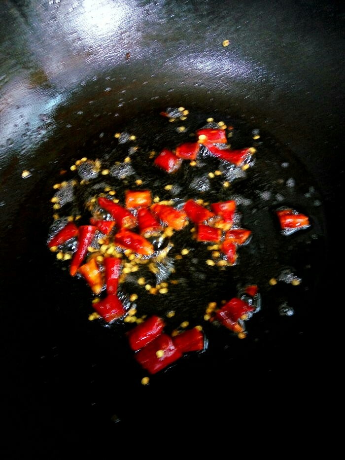 蕨菜炒腊肉,将腊肉捞出，下干椒节到锅里用腊肉油将干椒节煸炒出椒香味。