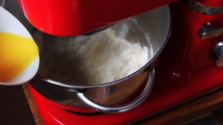 椰蓉花色面包卷,加入鸡蛋液搅拌。